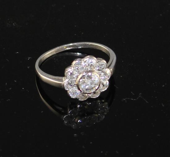 A white metal and eleven stone diamond circular cluster ring, size K, gross weight 3.1 grams.